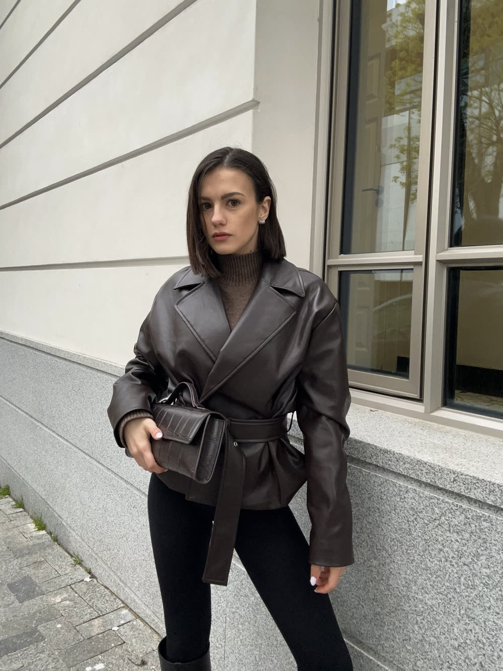 Editorial portrait of Mirela Ilieva wearing a brown leather jacket.