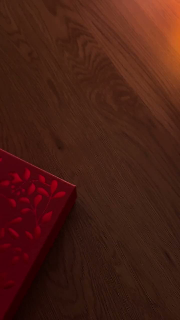 Mirela's hand opening a red floral-embossed gift box for a product reveal UGC video.